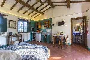 a bedroom with a bed and a kitchen with a table at casina MeMe in Pescia