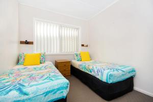 a bedroom with two beds and a window at Boorolong 3 - Linen not provided in Yamba
