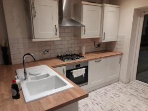 una cocina con fregadero y estufa en Melverley House, en Mánchester