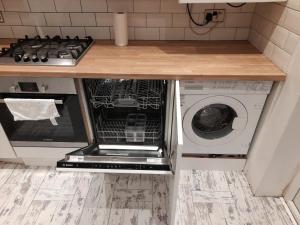 an open dishwasher in a kitchen with a stove at Melverley House in Manchester