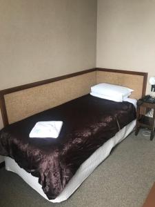 a bed in a room with two pillows on it at Grand Hotel - Whangarei in Whangarei