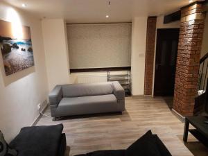 sala de estar con sofá de cuero en una habitación en Melverley House, en Mánchester