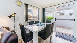 a dining room with a white table and chairs at Red Rock in Yamba