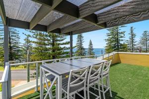 a patio with a table and chairs on a balcony at Seaspray 1 in Yamba
