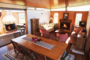 ein Wohnzimmer mit Tisch und Kamin in der Unterkunft Toumbaal Plains - Exquisite architecturally designed home in Brooms Head