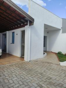 a white house with a brick driveway at Lindo quarto c/ banheiro privativo in Jaú