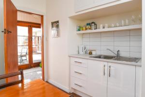 una cucina con armadi bianchi e lavandino di Sunny Mornington 2 Bedroom Guest Suite a Dunedin Altre 13 foto