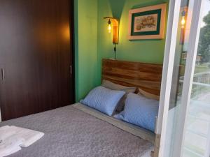 Cama pequeña en habitación con paredes verdes en ApartHotel Nathalie B207 a 7min Parque del Café, en Montenegro