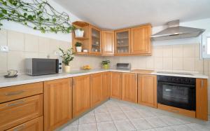 a kitchen with wooden cabinets and a stove top oven at Bucket List - Hvar in Hvar