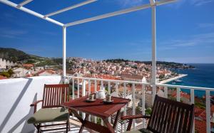 a table and chairs on a balcony with a view of the city at Bucket List - Hvar in Hvar