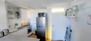 Una cocina con refrigerador y fregadero. en Sky High on Arundel - central Fremantle apartment, en Fremantle