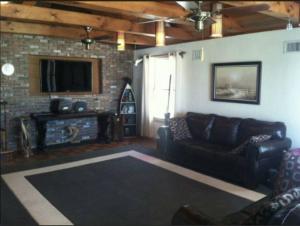 a living room with a couch and a tv at Oceanfront Home + Private Beach + Pool in Mantoloking