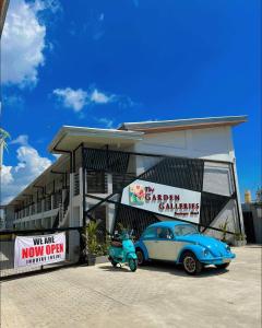 a blue car parked in front of a car garage at The Garden Galleries Boutique Hotel in Pilar