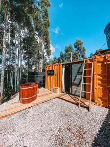 a tiny house with a deck and a cabin at Container ABOBORA na natureza da Serra Gaúcha in Flores da Cunha