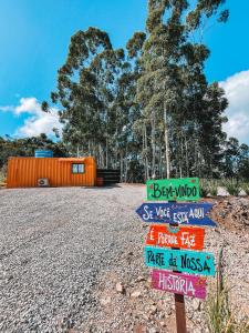 a group of signs on the side of a road at Container ABOBORA na natureza da Serra Gaúcha in Flores da Cunha