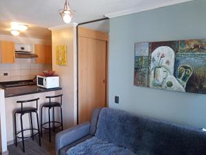 a living room with a couch and a kitchen at Departamento Amoblado Vacaciones Cavancha in Iquique