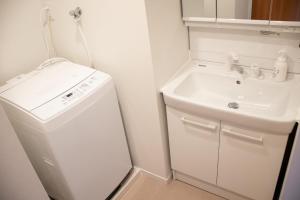 a small bathroom with a sink and a white refrigerator at Hotel S-Presso West - Vacation STAY 9085 in Osaka