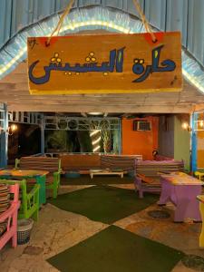 a play room with wooden benches and a sign at Bishbishi Camp Dahab in Dahab