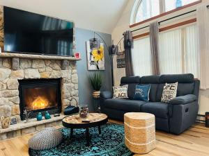 a living room with a couch and a fireplace at Nature Escape Resort With Large Private Deck, Hot Tub, BBQ Grills, at Arrowhead Lake with 3 Pools, 4 Beaches at the Lakes and MORE in Thornhurst