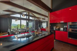 uma cozinha com armários vermelhos e uma sala de jantar em Akatsuki em Niseko