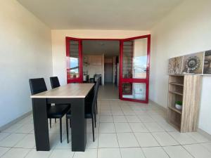 een eetkamer met een houten tafel en zwarte stoelen bij T2 lumineux au calme in Cayenne +2 foto's