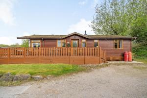 a house with a wooden fence in front of it at Lakeview Lodge in Carnforth