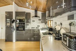 eine Küche mit Küchengeräten aus Edelstahl und Holzdecken in der Unterkunft Lakeview Lodge in Carnforth