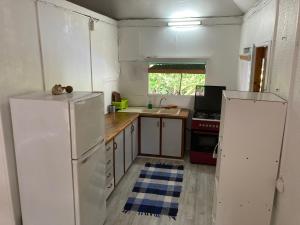 
a kitchen with a refrigerator, stove, sink and cabinets at Manomano Lodge in Papara
