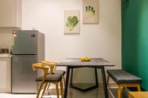 a kitchen with a table and chairs and a refrigerator at 3 Tower by Plush in Kuala Lumpur