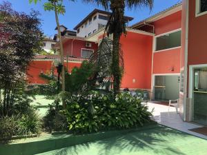 ウバトゥバにあるSuítes Ubatuba Praia da Lagoinhaの赤い木の中庭