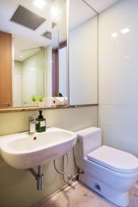 a bathroom with a sink and a toilet and a mirror at Soho Suites KLCC by GuestHouse in Kuala Lumpur