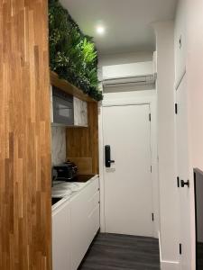 a kitchen with white cabinets and a white door at Brick Lane Base in London