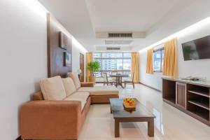 a living room with a couch and a table at Pinnacle Lumpinee Park Hotel SHA Plus in Bangkok