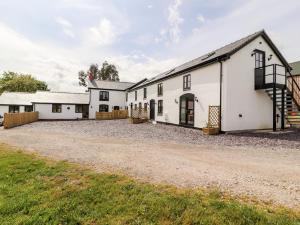 an exterior view of a white building with a driveway at Colomendy Alpaca Farm - Farm House in Mold