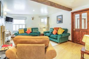 ein Wohnzimmer mit 2 grünen Sofas in der Unterkunft Saddlers Cottage in Matlock