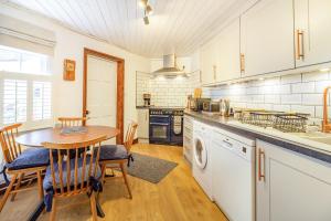 eine Küche mit einem Holztisch und einem Tisch und Stühlen in der Unterkunft Saddlers Cottage in Matlock + 6 Fotos