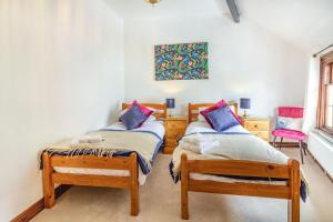 ein Schlafzimmer mit zwei Einzelbetten und einem Fenster in der Unterkunft Saddlers Cottage in Matlock