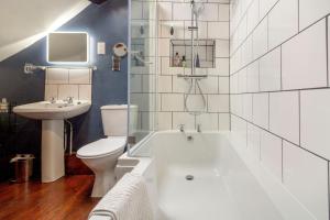 ein Badezimmer mit Badewanne, Toilette und Waschbecken in der Unterkunft Saddlers Cottage in Matlock