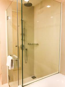 a shower with a glass door in a bathroom at 163 KLCC by Plush in Kuala Lumpur