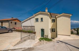 a white house with a car parked in a driveway at Nevera 1 in Vrbnik