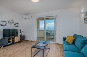 a living room with a blue couch and a tv at Nevera 1 in Vrbnik