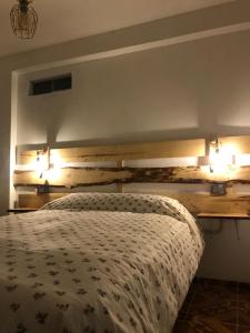 a bedroom with a bed with two lights on the wall at Casa de Ana B&B in Huaraz +22 photos