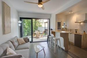 a living room with a couch and a kitchen with a table at Le Grand Bleu - Jacuzzi - apt la Saline les Bains in La Saline les Bains