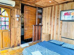 1 dormitorio con 1 cama en una habitación de madera en Mobylette Sai Gon, en Ho Chi Minh