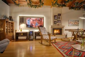 a living room with a fireplace and a tv at IQOQO HOTELS - luxury suites Ioannina in Ioannina
