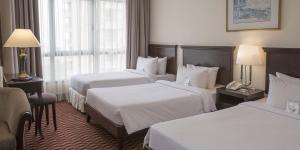A bed or beds in a room at Berjaya Penang Hotel
