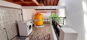 a washing machine and a yellow container in a room at The Balisunny House in Denpasar