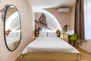 een slaapkamer met een bed en een spiegel bij PJACA CITY ROOMS in Split