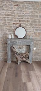 a table with a mirror on it next to a brick wall at Gîte chez Marianne- la halte Jurassienne in Montmorot