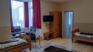 a room with a room with two beds and a television at Pension Lehmann in Radebeul